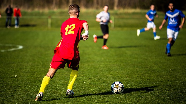 Soccer player scoring a goal in a packed stadium during a crucial league match